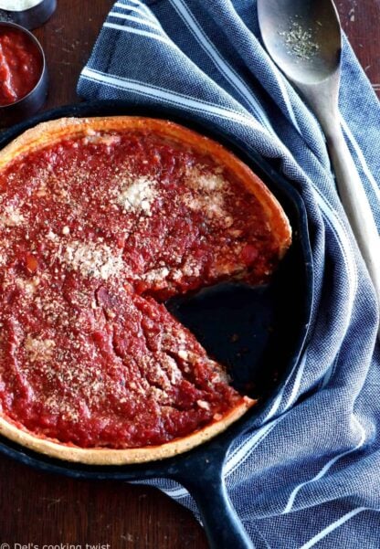 Discover the authentic Chicago-style deep dish pizza, made with a crunchy flaky crust and garnished with thick layers of cheese and tomato sauce.