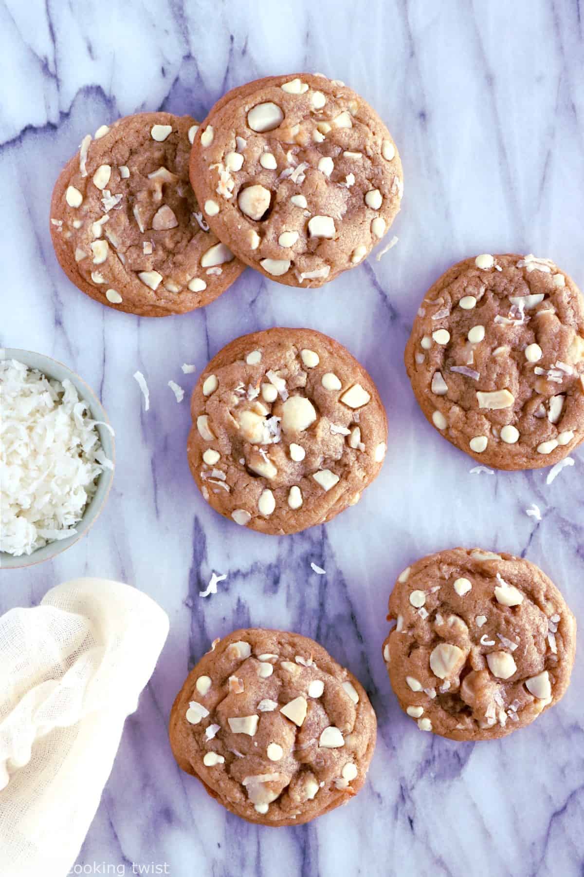 Cookies au chocolat blanc, noix de coco et noix de macadamia. Plongez dans la douceur de ces cookies au chocolat blanc, noix de coco et noix de macadamia à la texture à la fois souple et légèrement croustillante sur les côtés. Amoureux de chocolat blanc, cette recette est pour vous !