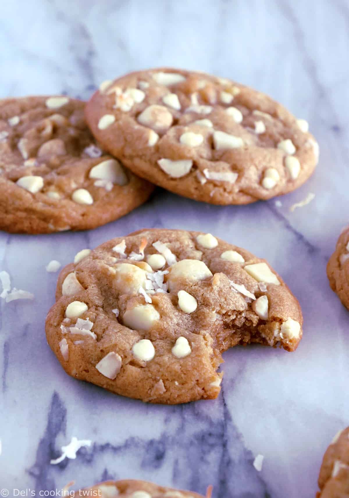 Cookies au chocolat blanc, noix de coco et noix de macadamia. Plongez dans la douceur de ces cookies au chocolat blanc, noix de coco et noix de macadamia à la texture à la fois souple et légèrement croustillante sur les côtés. Amoureux de chocolat blanc, cette recette est pour vous !