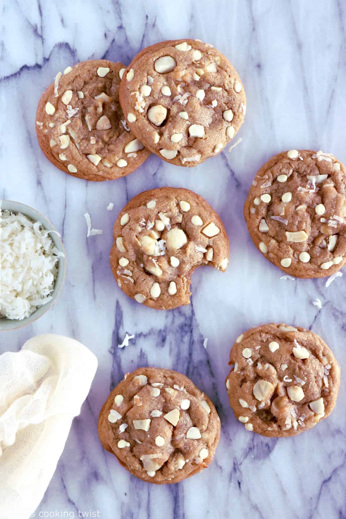 Cookies au chocolat blanc, noix de coco et noix de macadamia. Plongez dans la douceur de ces cookies au chocolat blanc, noix de coco et noix de macadamia à la texture à la fois souple et légèrement croustillante sur les côtés. Amoureux de chocolat blanc, cette recette est pour vous !