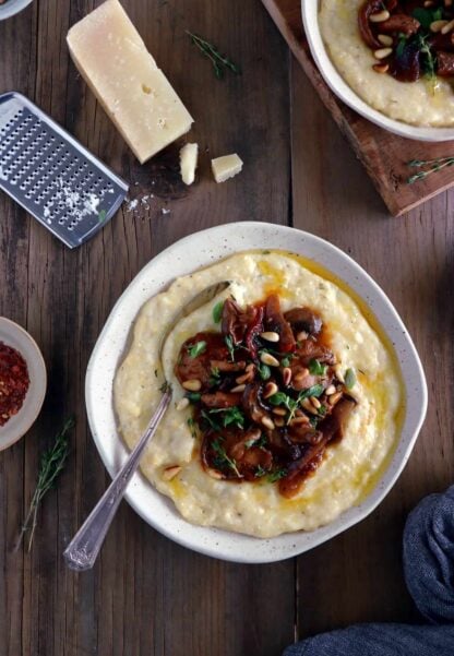 La polenta aux champignons, thym et parmesan est un plat élégant et crémeux aux saveurs automnales. Parfait pour se réchauffer aux premiers jours de fraîcheur, il s'accompagne volontiers d'un verre de vin.