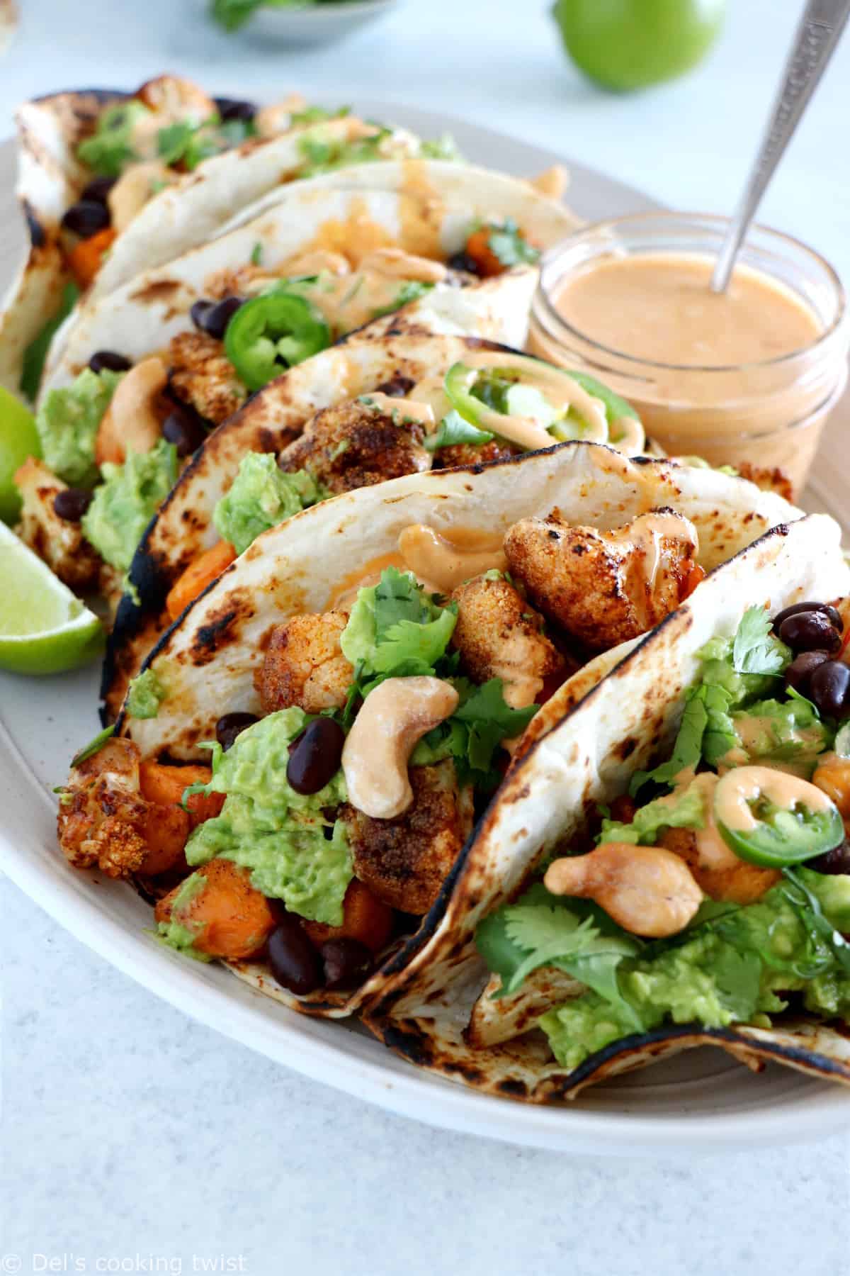 Spicy Vegan Sweet Potato and Cauliflower Tacos. Healthy vegan tacos filled with roasted sweet potato and cauliflower, mashed avocado and topped with a spicy cashew sauce. They are loaded with healthy and hearty flavors and make a perfect, quick, and easy weeknight dinner. These tacos are Oh SO good!