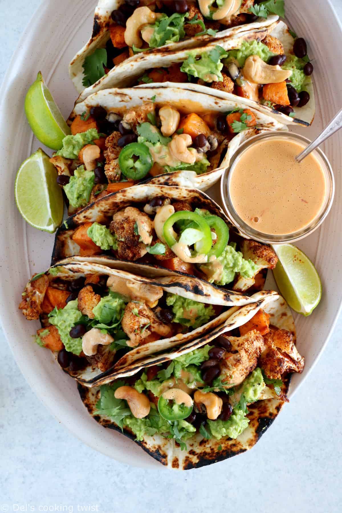 Spicy Vegan Sweet Potato and Cauliflower Tacos. Healthy vegan tacos filled with roasted sweet potato and cauliflower, mashed avocado and topped with a spicy cashew sauce. They are loaded with healthy and hearty flavors and make a perfect, quick, and easy weeknight dinner. These tacos are Oh SO good!