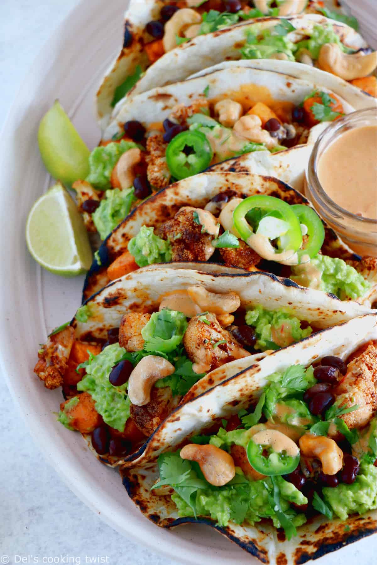 Spicy Vegan Sweet Potato and Cauliflower Tacos. Healthy vegan tacos filled with roasted sweet potato and cauliflower, mashed avocado and topped with a spicy cashew sauce. They are loaded with healthy and hearty flavors and make a perfect, quick, and easy weeknight dinner. These tacos are Oh SO good!