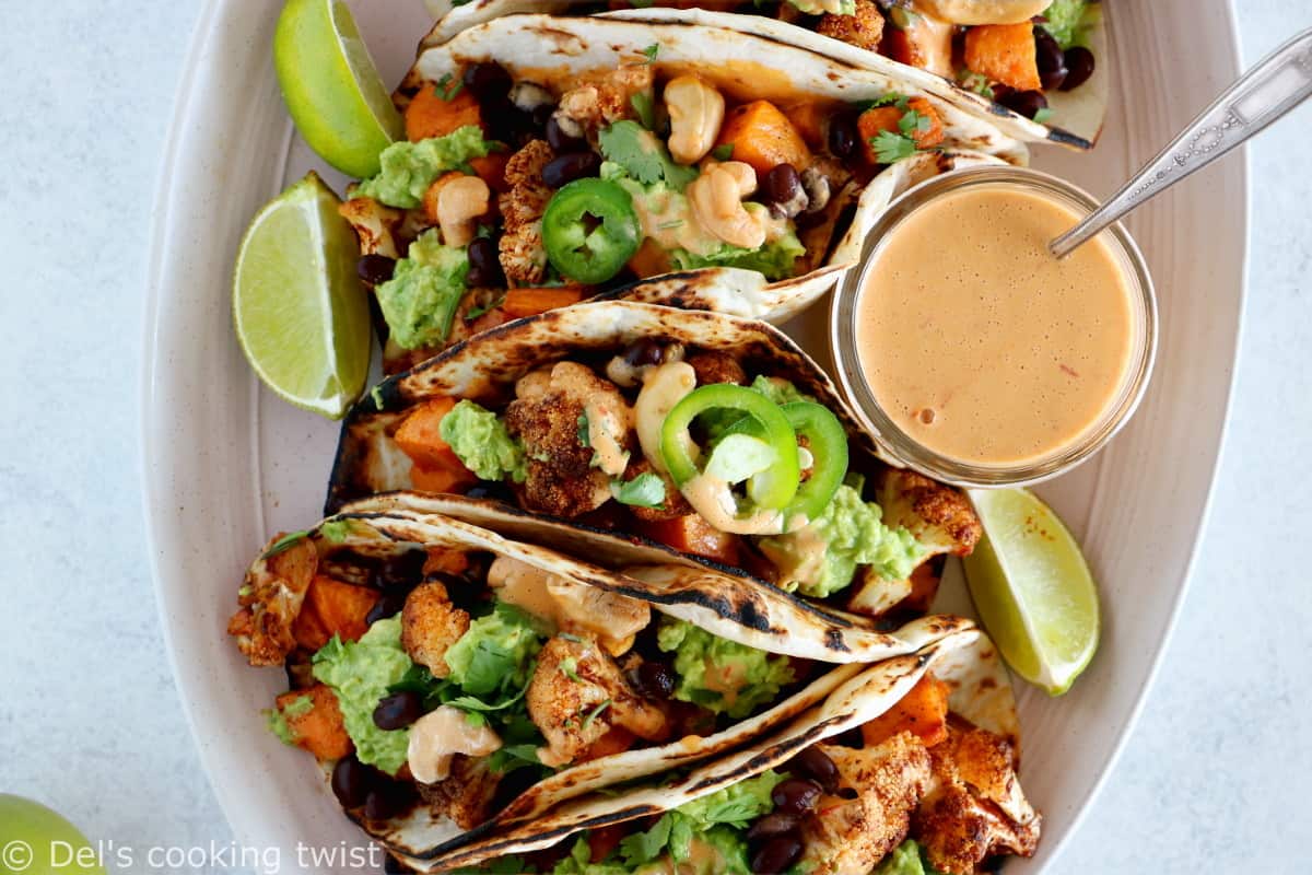 Spicy Vegan Sweet Potato and Cauliflower Tacos. Healthy vegan tacos filled with roasted sweet potato and cauliflower, mashed avocado and topped with a spicy cashew sauce. They are loaded with healthy and hearty flavors and make a perfect, quick, and easy weeknight dinner. These tacos are Oh SO good!