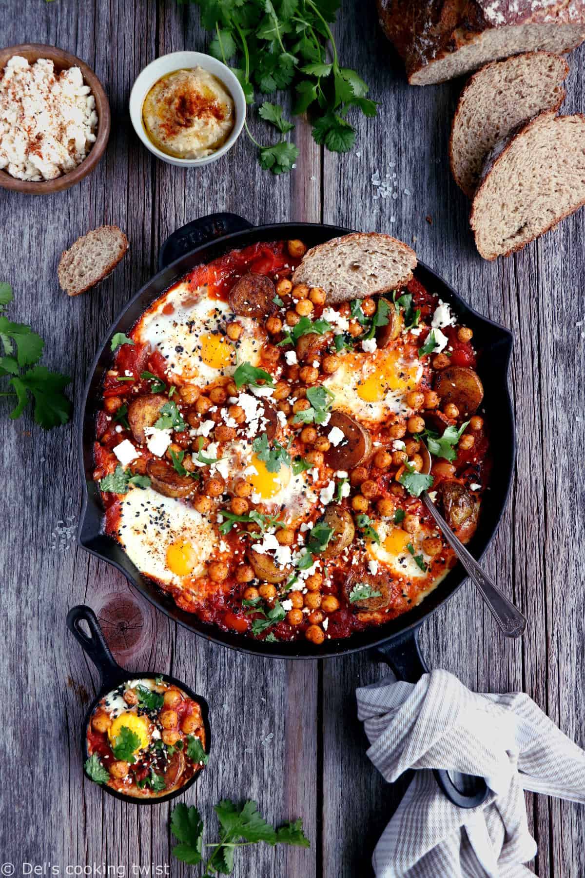 Une shakshuka en version deluxe, avec une base d'oeufs pochés plongés dans une sauce tomate aux oignons, le tout réhaussé de pommes de terres et pois chiches épicés.