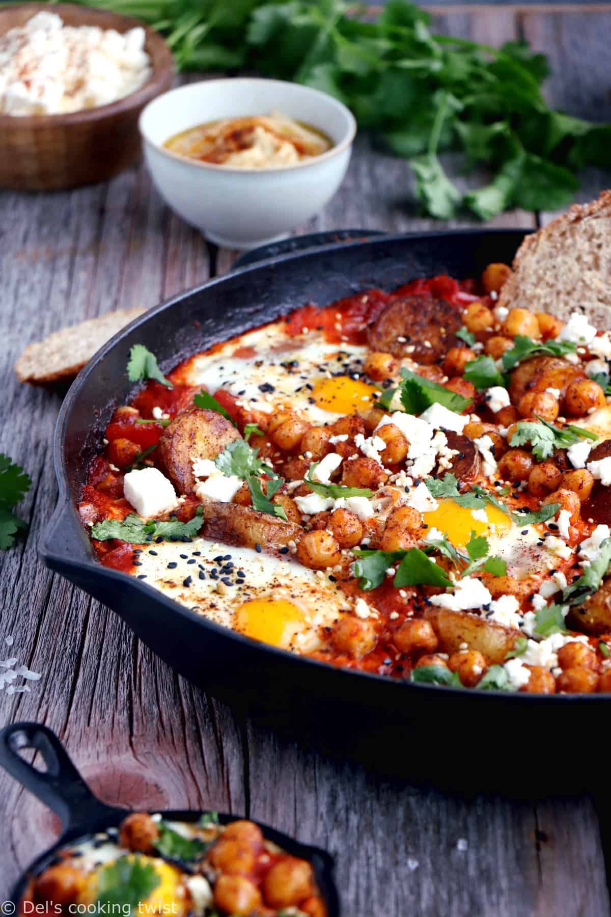 Une shakshuka en version deluxe, avec une base d'oeufs pochés plongés dans une sauce tomate aux oignons, le tout réhaussé de pommes de terres et pois chiches épicés.