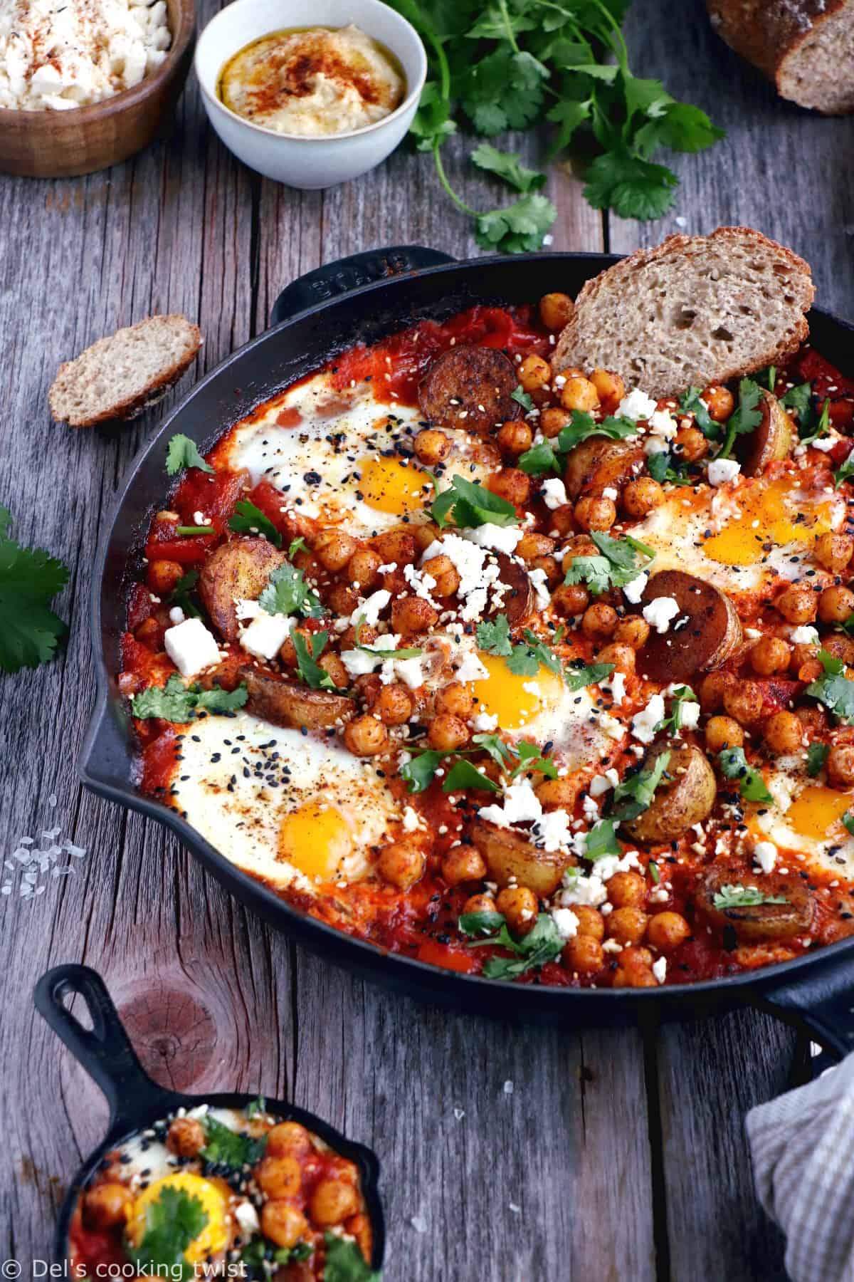 Une shakshuka en version deluxe, avec une base d'oeufs pochés plongés dans une sauce tomate aux oignons, le tout réhaussé de pommes de terres et pois chiches épicés.