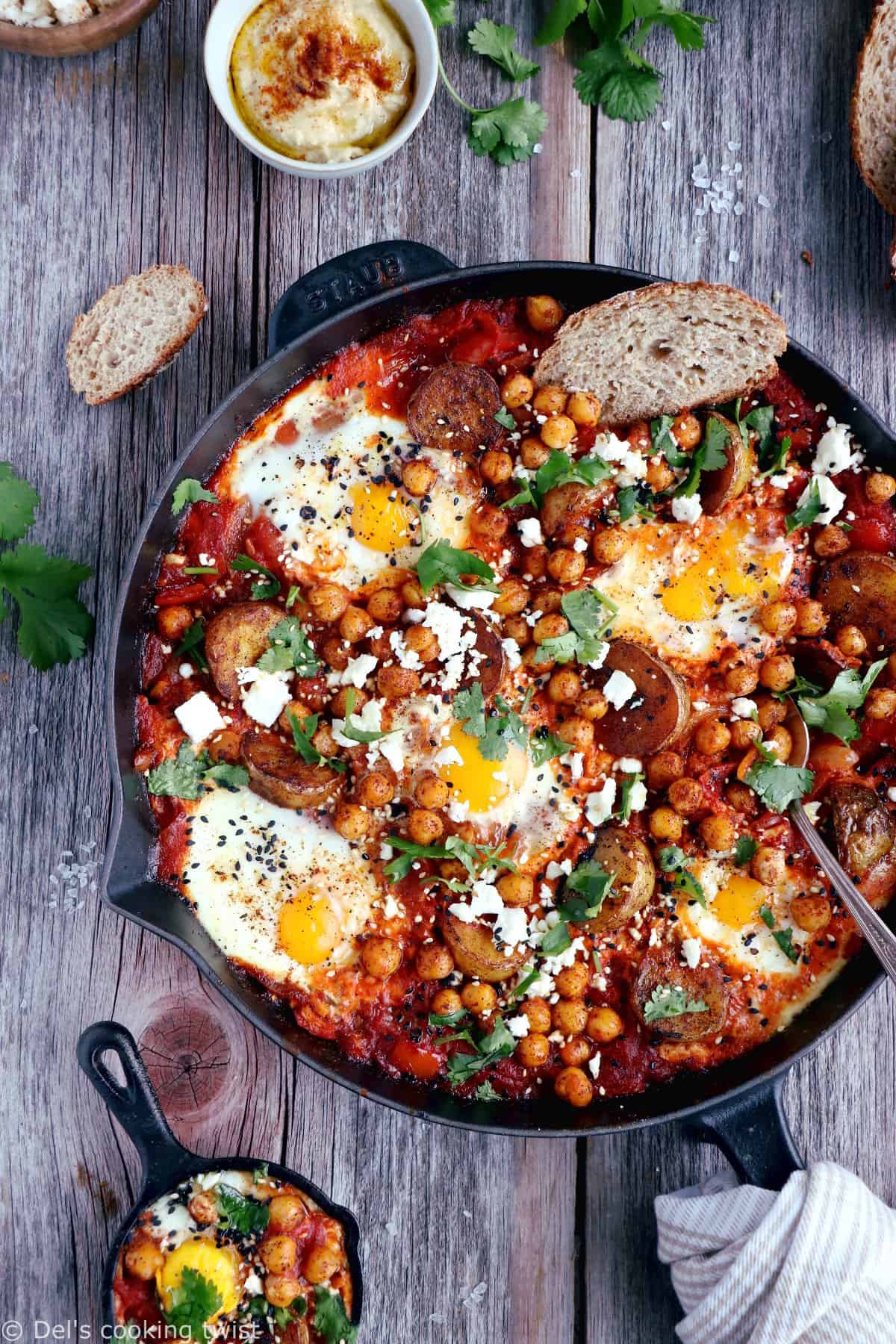 Une shakshuka en version deluxe, avec une base d'oeufs pochés plongés dans une sauce tomate aux oignons, le tout réhaussé de pommes de terres et pois chiches épicés.