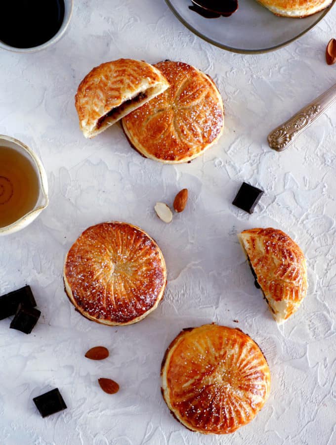 These mini galettes des rois are a rich almond paste and puff pastry confection which commemorates the Epiphany. Add a twist of chocolate and pears, and it becomes the most delightful dessert.