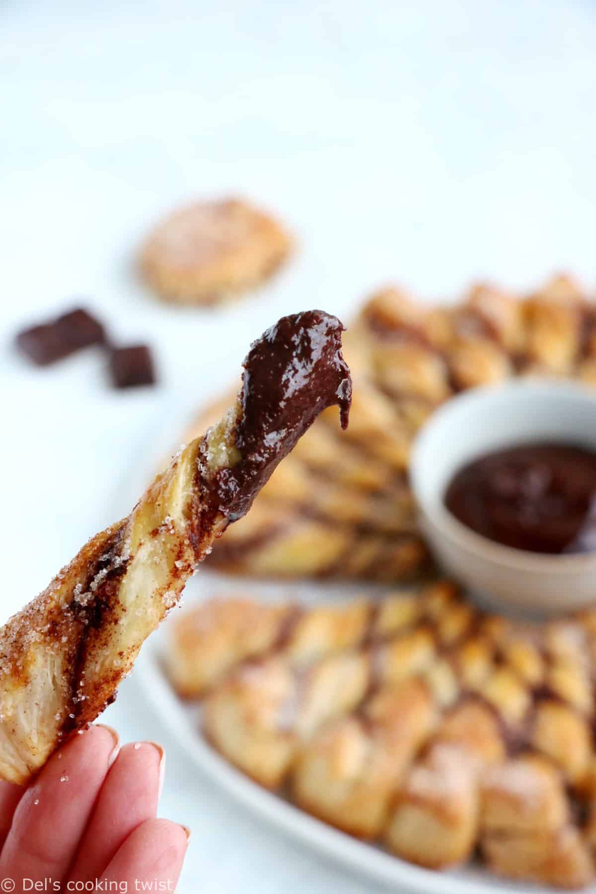 Vous ne résisterez pas à cette tarte soleil façon churros. Déchirez les torsades de pâte feuilletée recouvertes d'un mélange sucre-cannelle, trempez-les dans la sauce au chocolat chaud et dévorez sans plus attendre.