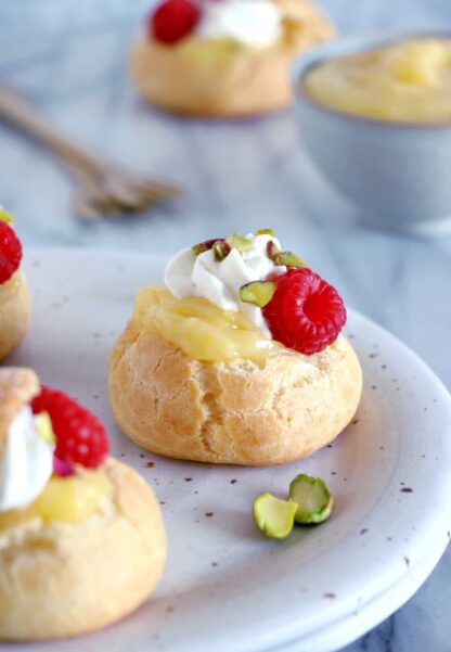 Ces petits choux au lemon curd et aux framboises constituent un dessert tout en élégance, frais et acidulé. Réalisés avec une pâte à choux facile à réaliser, ils feront le bonheur des gourmets et gourmands.