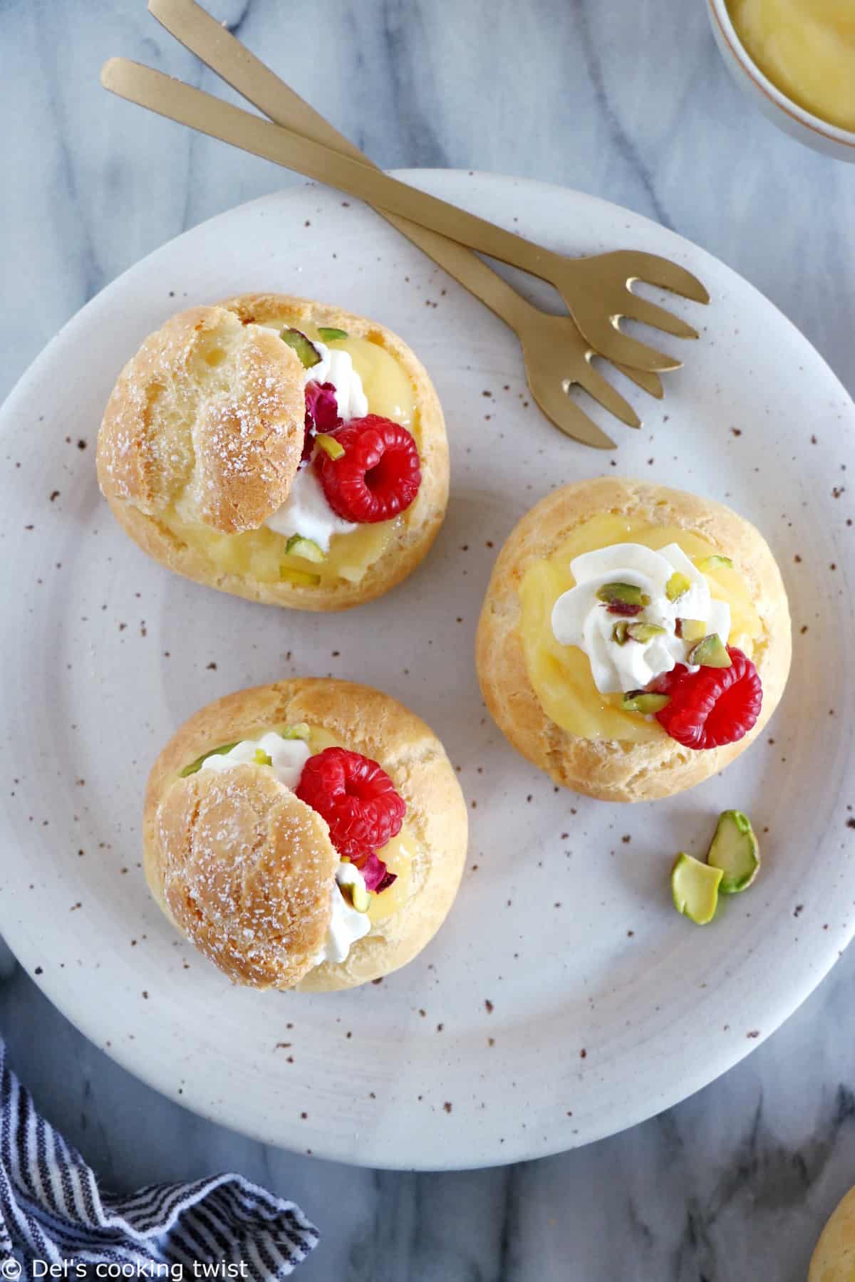 Easy raspberry and lemon curd cream puffs make a delicious fancy sweet dessert with a lovely touch of acidity brought by the homemade lemon curd and the fresh raspberries.