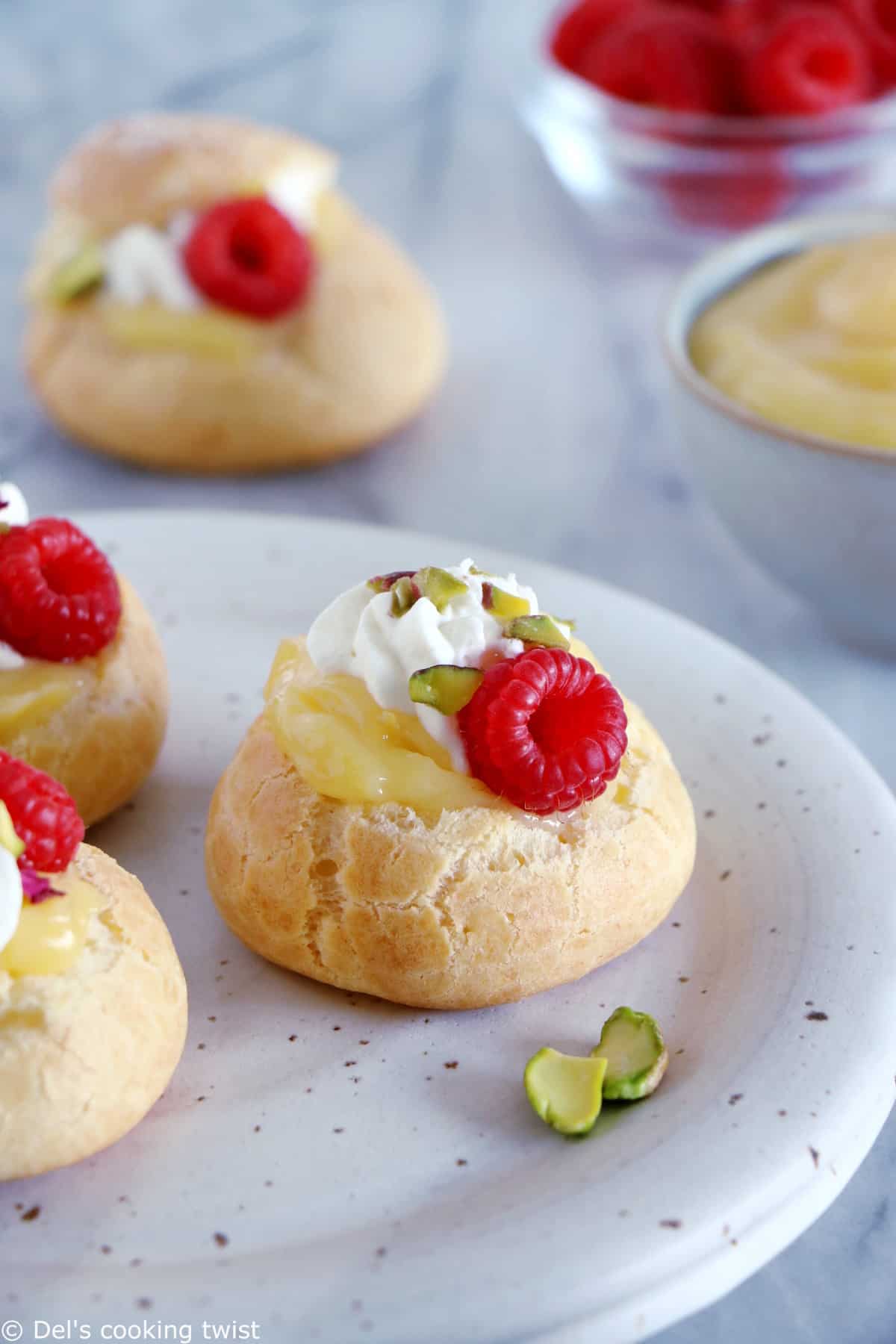 Easy raspberry and lemon curd cream puffs make a delicious fancy sweet dessert with a lovely touch of acidity brought by the homemade lemon curd and the fresh raspberries.