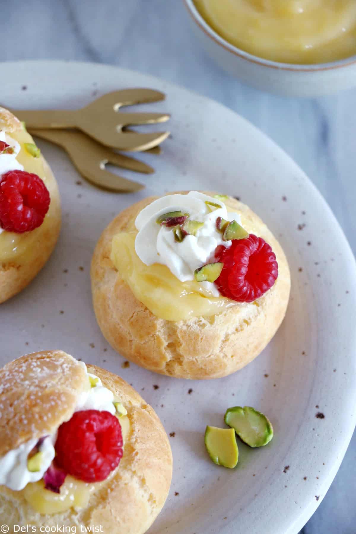 Easy raspberry and lemon curd cream puffs make a delicious fancy sweet dessert with a lovely touch of acidity brought by the homemade lemon curd and the fresh raspberries.
