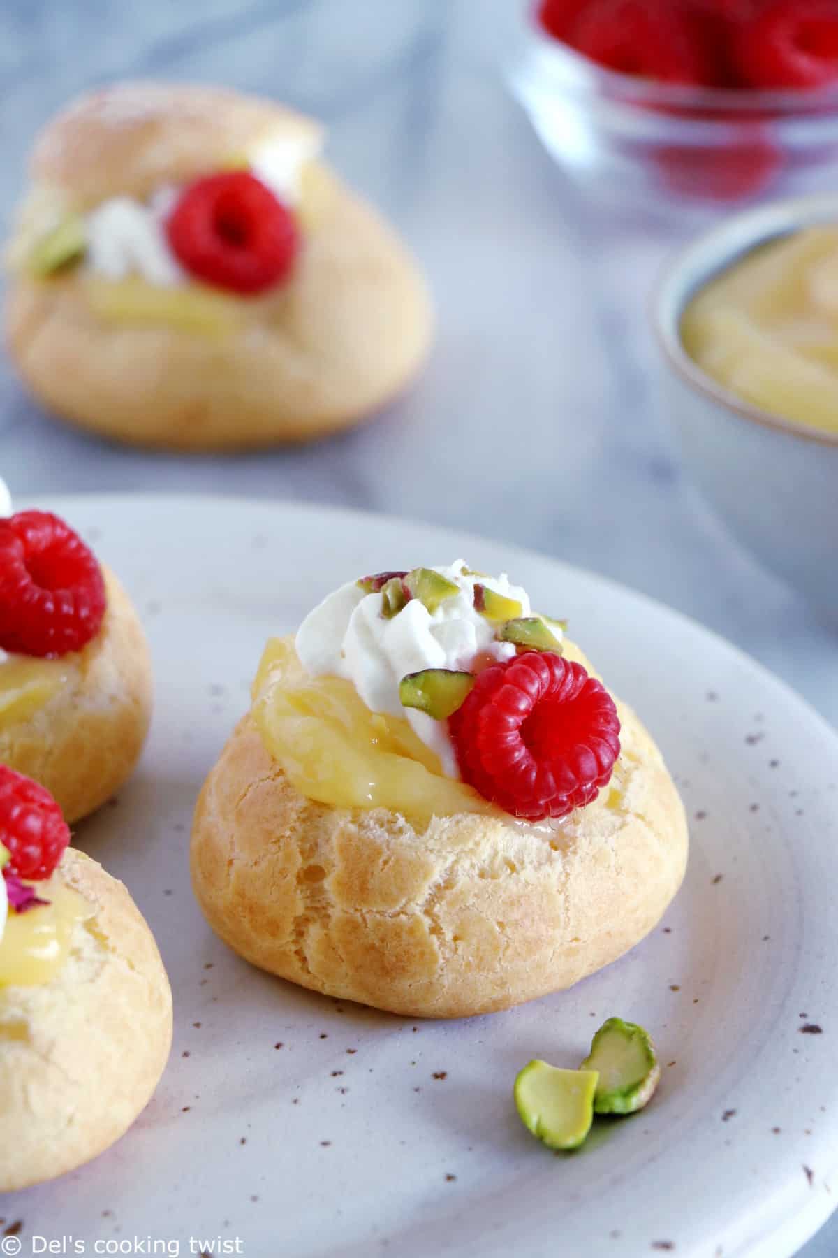 Ces petits choux au lemon curd et aux framboises constituent un dessert tout en élégance, frais et acidulé. Réalisés avec une pâte à choux facile à réaliser, ils feront le bonheur des gourmets et gourmands.