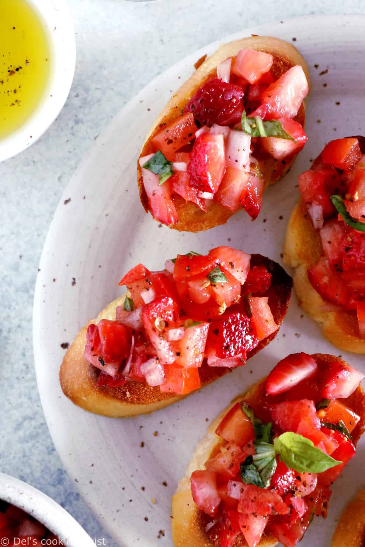 Faciles et rapides à préparer, les bruschetta aux tomates, fraises et basilic sont l'antipasti par excellence à servir pour les apéritifs entre amis.