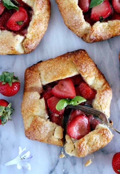 Ces petites tartes rustiques aux fraises et basilic, généreusement servies en portions individuelles, ont de quoi régaler tous les gourmands.