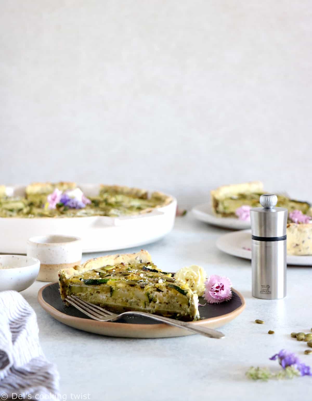 This delicious zucchini quiche features fresh goat cheese, pesto, and a subtle pie crust with seeds.