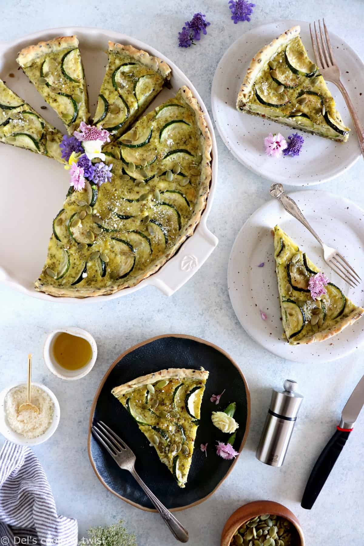 This delicious zucchini quiche features fresh goat cheese, pesto, and a subtle pie crust with seeds.