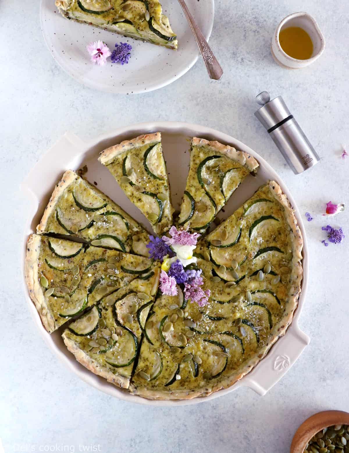 This delicious zucchini quiche features fresh goat cheese, pesto, and a subtle pie crust with seeds.