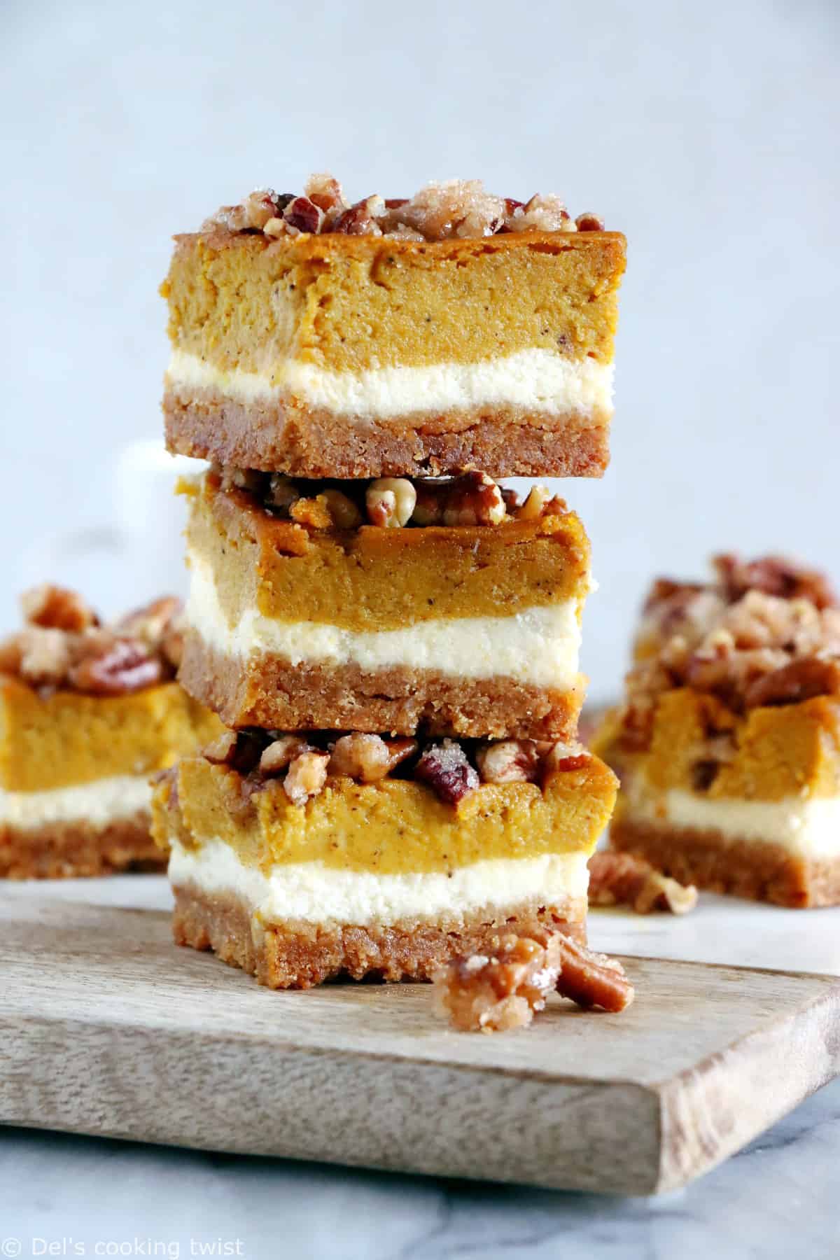 These amazing pumpkin cheesecake bars with candied pecans are delicious and so EASY to make! Full of fall spices, the 4 layers come easily together in a sumptuous dessert that is sure to impress at any holiday gathering.