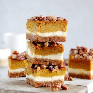 These amazing pumpkin cheesecake bars with candied pecans are delicious and so EASY to make! Full of fall spices, the 4 layers come easily together in a sumptuous dessert that is sure to impress at any holiday gathering.