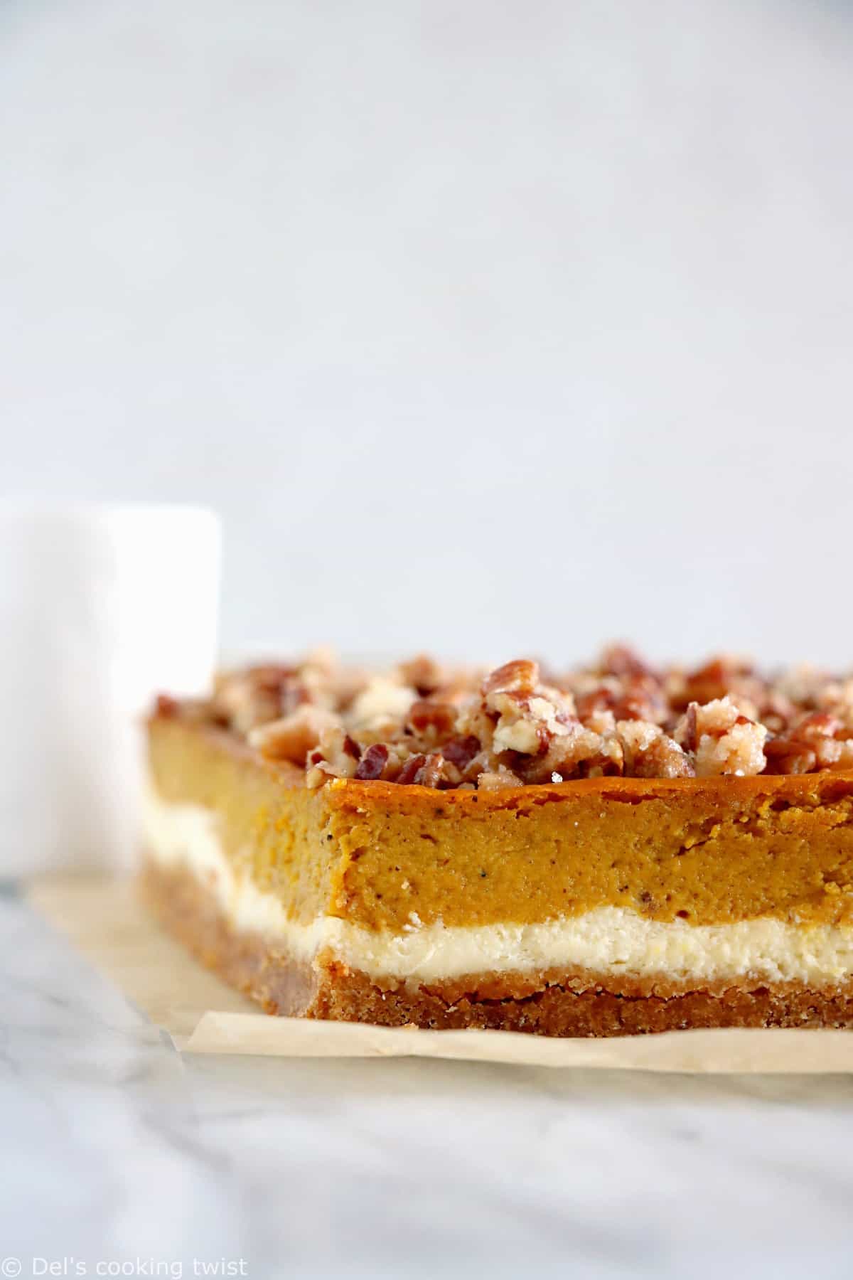 These amazing pumpkin cheesecake bars with candied pecans are delicious and so EASY to make! Full of fall spices, the 4 layers come easily together in a sumptuous dessert that is sure to impress at any holiday gathering.