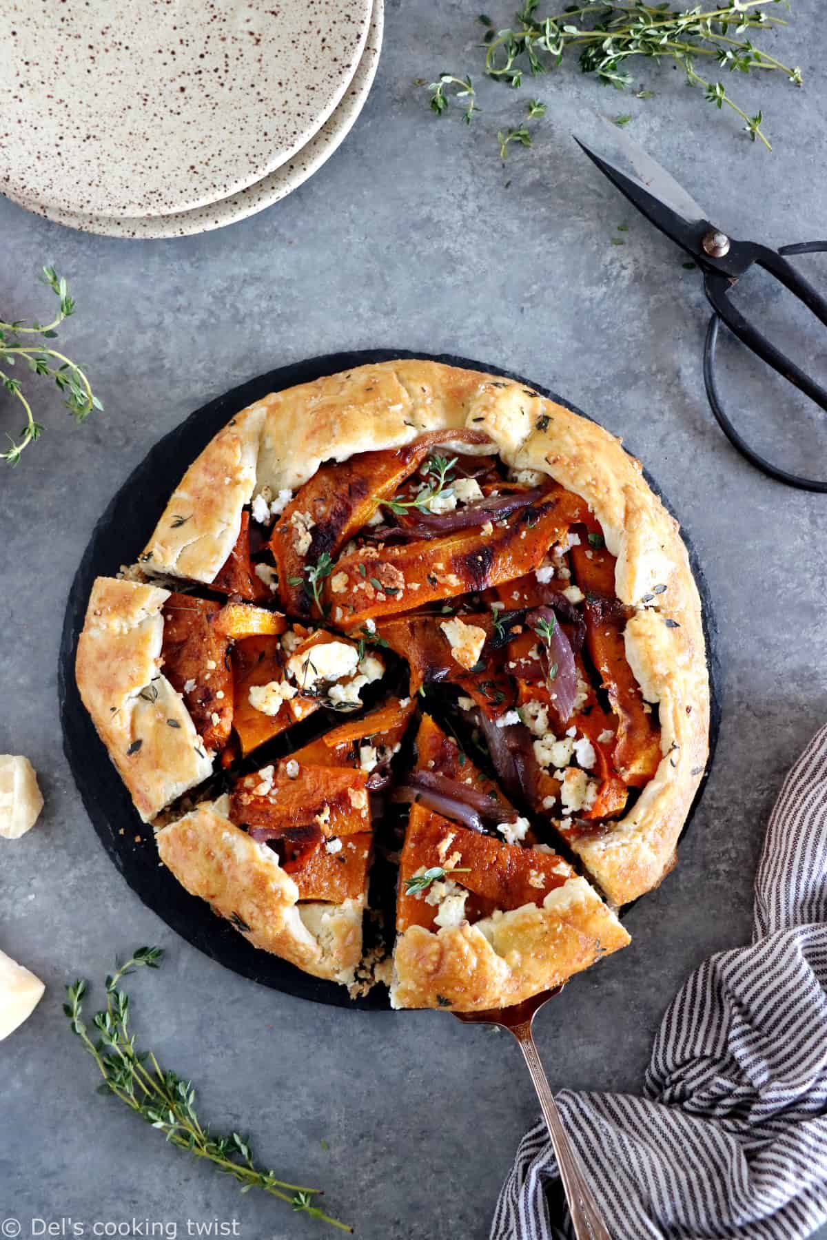 Dans cette galette de courge butternut au parmesan, on y retrouve des oignons caramélisés, de la feta, des tranches de courge butternut rôties au four avec du thym, recouverts d'une pâte à tarte au parmesan croustillante à souhait.