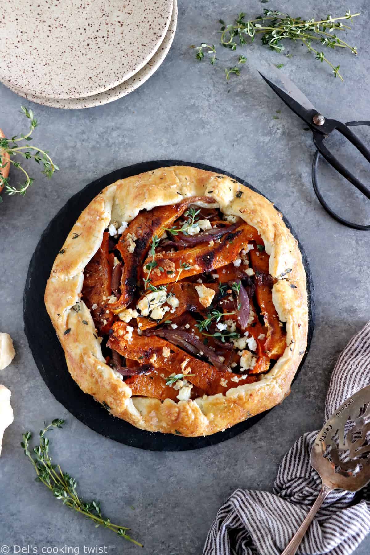 Dans cette galette de courge butternut au parmesan, on y retrouve des oignons caramélisés, de la feta, des tranches de courge butternut rôties au four avec du thym, recouverts d'une pâte à tarte au parmesan croustillante à souhait.