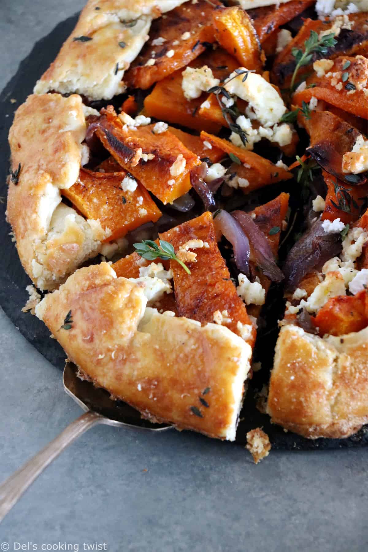 Dans cette galette de courge butternut au parmesan, on y retrouve des oignons caramélisés, de la feta, des tranches de courge butternut rôties au four avec du thym, recouverts d'une pâte à tarte au parmesan croustillante à souhait.