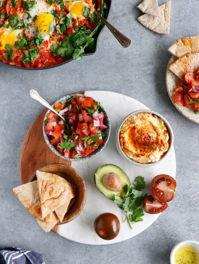 Ever wondered how to serve a shakshuka? Place it in the center of the table and serve with various small plates, breads and salads to make this meal a feast!