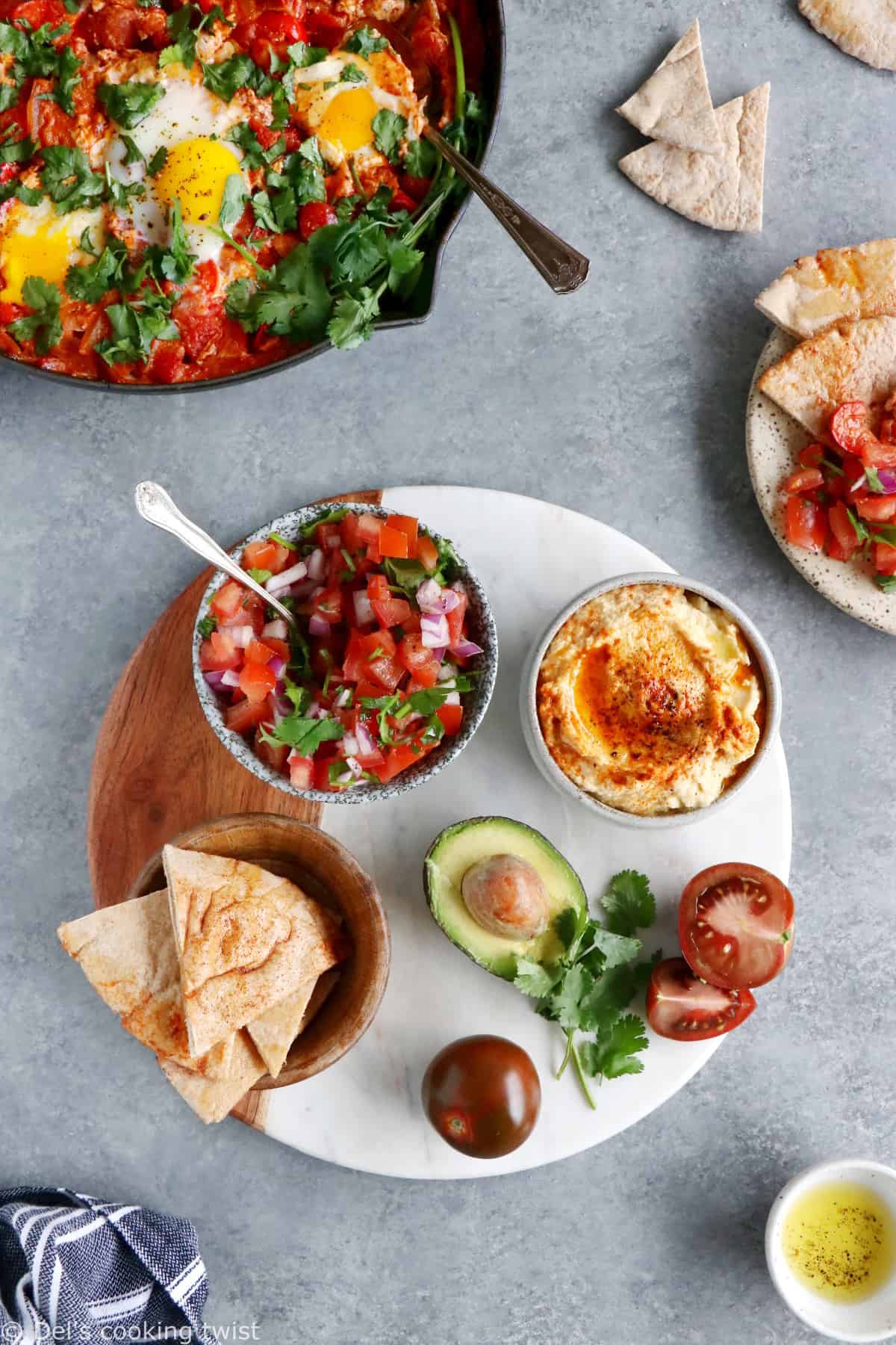 Comment servir une shakshuka ? Placez-la au centre de la table et accompagnez-la d'une déclinaison de petits plats, pains et salade pour faire du repas un véritable festin !