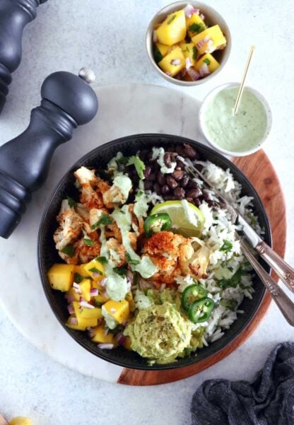 Un burrito bowl végétarien sain et nourrissant à la fois réalisé sur une base de riz parfumé à la coriandre et au citron vert. Délicieux !