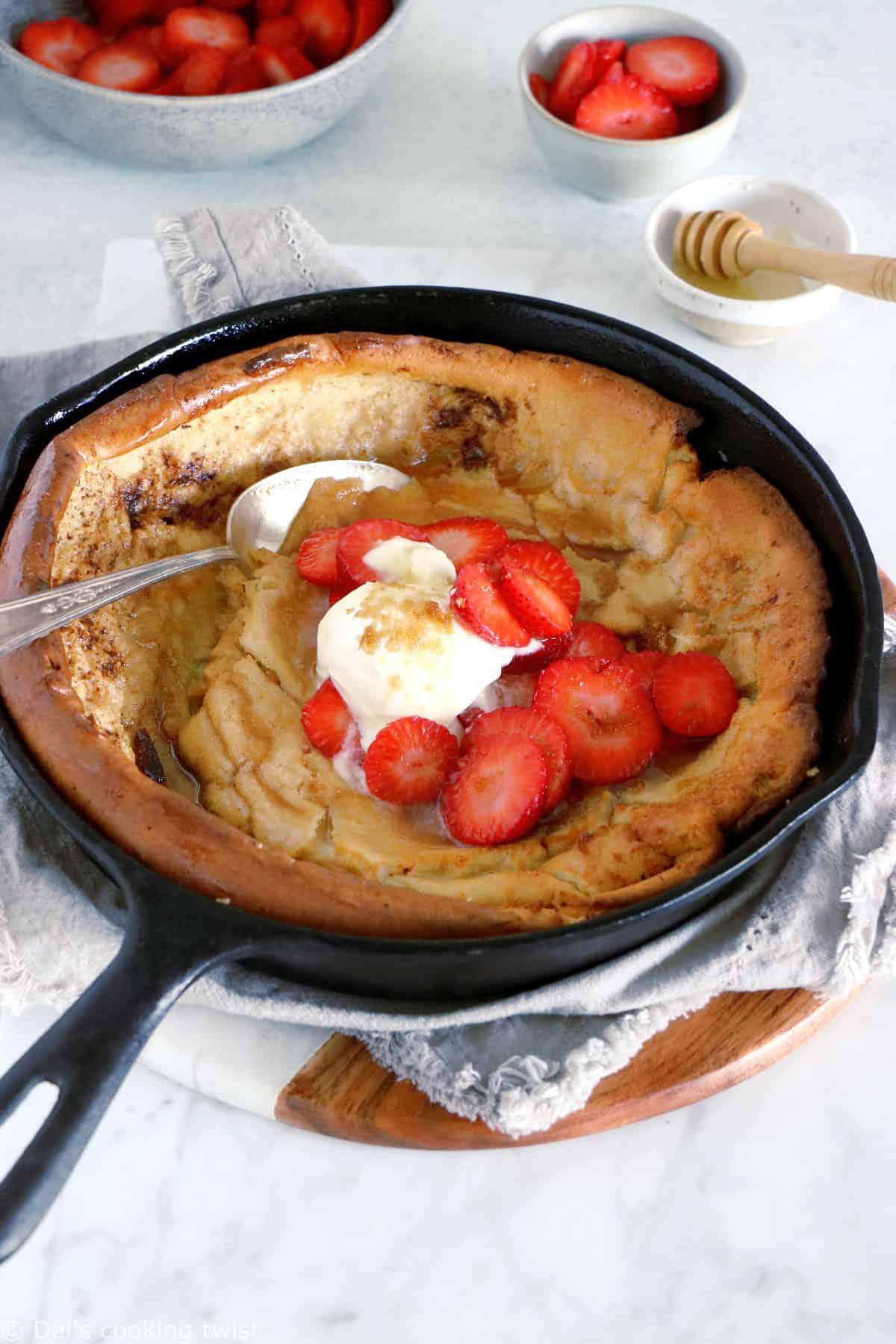 EASY brown butter Dutch Baby pancake with strawberries. It all happens in one pan, it's convivial and packed with delicious flavors of brown butter and cinnamon.