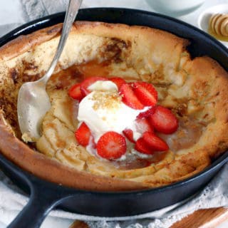 EASY brown butter Dutch Baby pancake with strawberries. It all happens in one pan, it's convivial and packed with delicious flavors of brown butter and cinnamon.