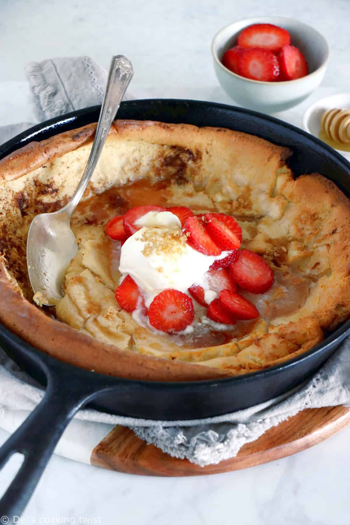 EASY brown butter Dutch Baby pancake with strawberries. It all happens in one pan, it's convivial and packed with delicious flavors of brown butter and cinnamon.