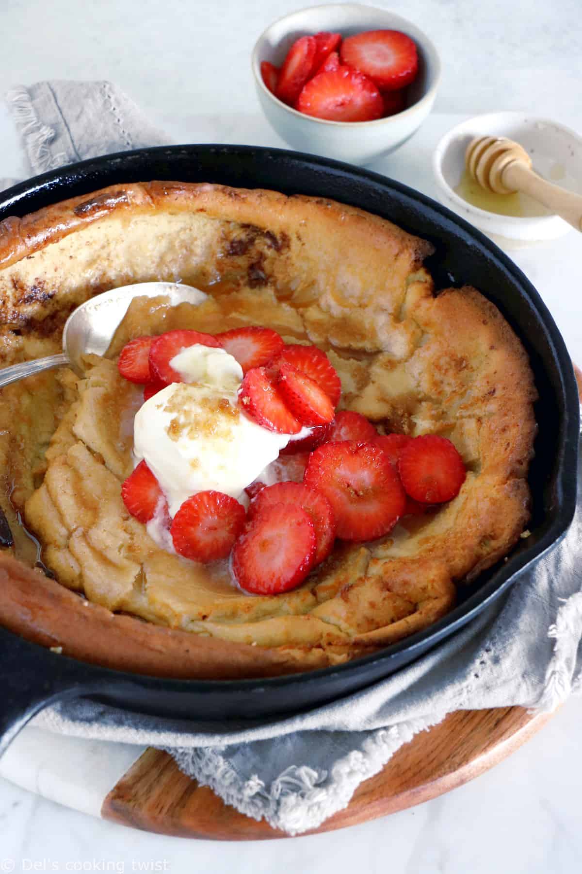 EASY brown butter Dutch Baby pancake with strawberries. It all happens in one pan, it's convivial and packed with delicious flavors of brown butter and cinnamon.