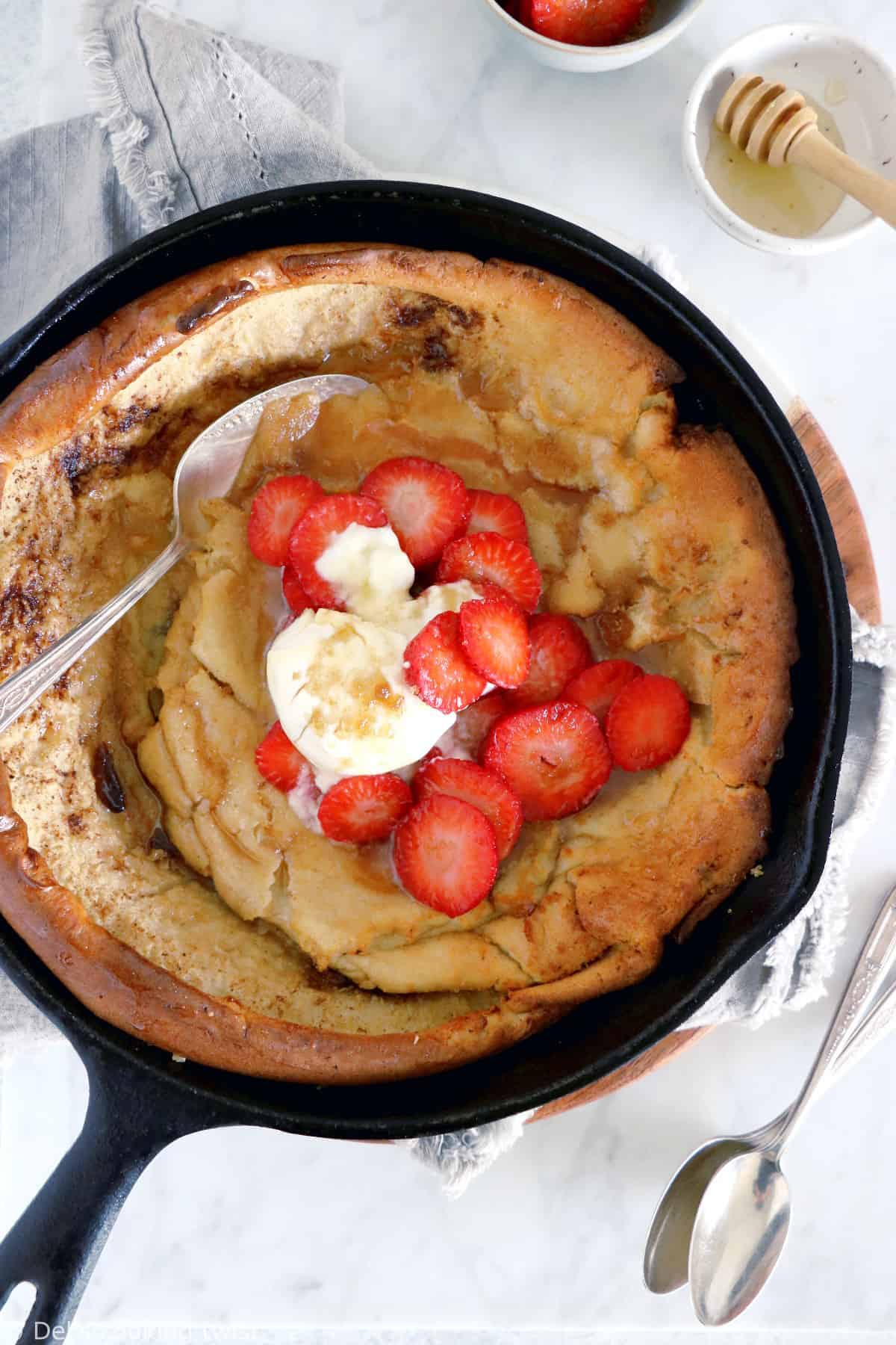 EASY brown butter Dutch Baby pancake with strawberries. It all happens in one pan, it's convivial and packed with delicious flavors of brown butter and cinnamon.