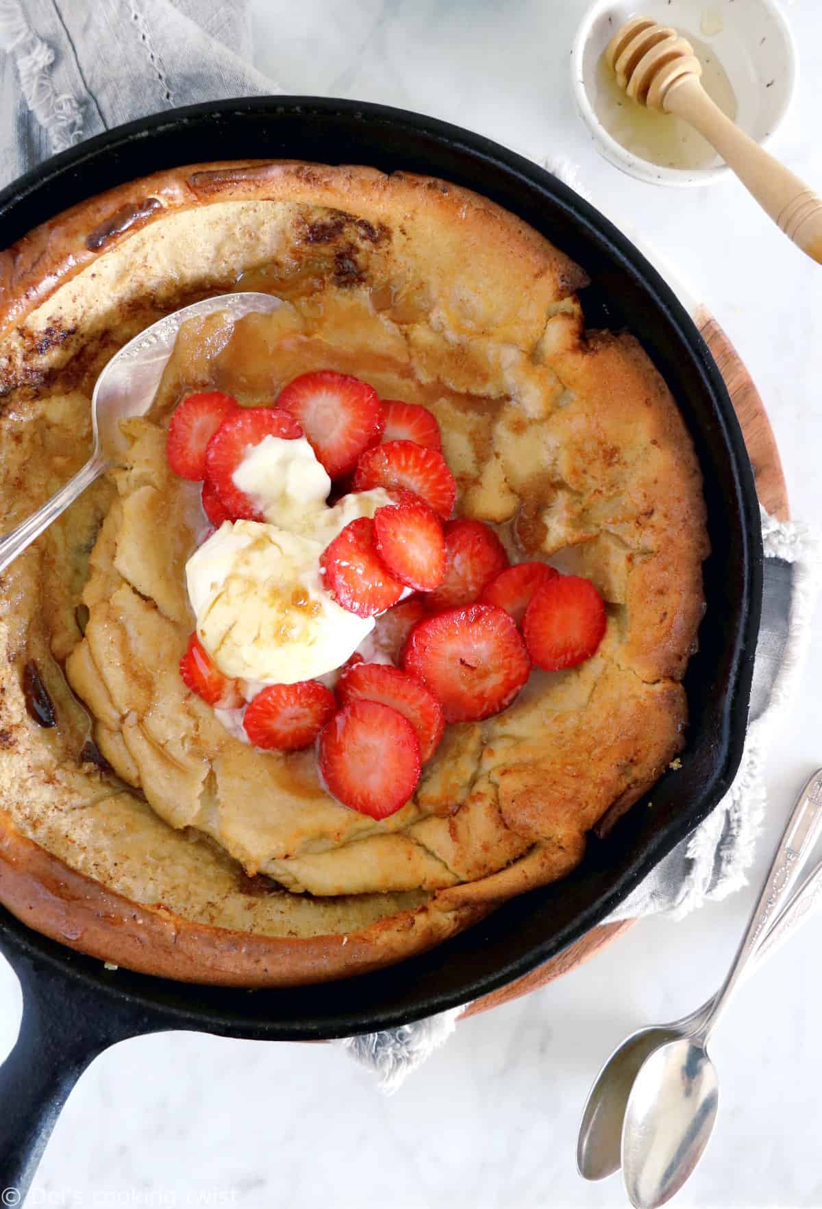 EASY brown butter Dutch Baby pancake with strawberries. It all happens in one pan, it's convivial and packed with delicious flavors of brown butter and cinnamon.