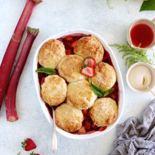 Le cobbler pommes, fraises, rhubarbe, c'est un dessert qui réunit des fruits juteux et sucrés sous une généreuse couche de biscuits tendres et moelleux.