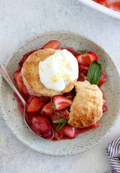 This rhubarb, strawberry, apple cobbler features a sweet and tangy fruity filling topped with some flaky dropped biscuits.