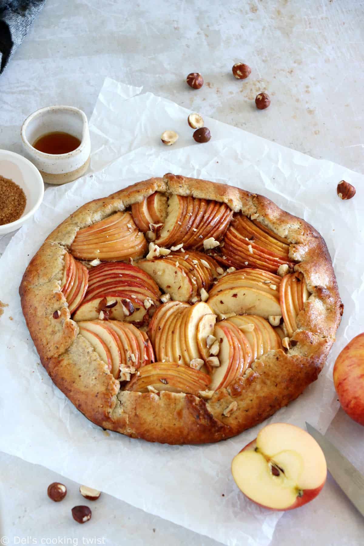 La tarte rustique aux pommes et aux noisettes est une tarte toute simple réalisée avec une pâte aux noisettes absolument irrésistible.