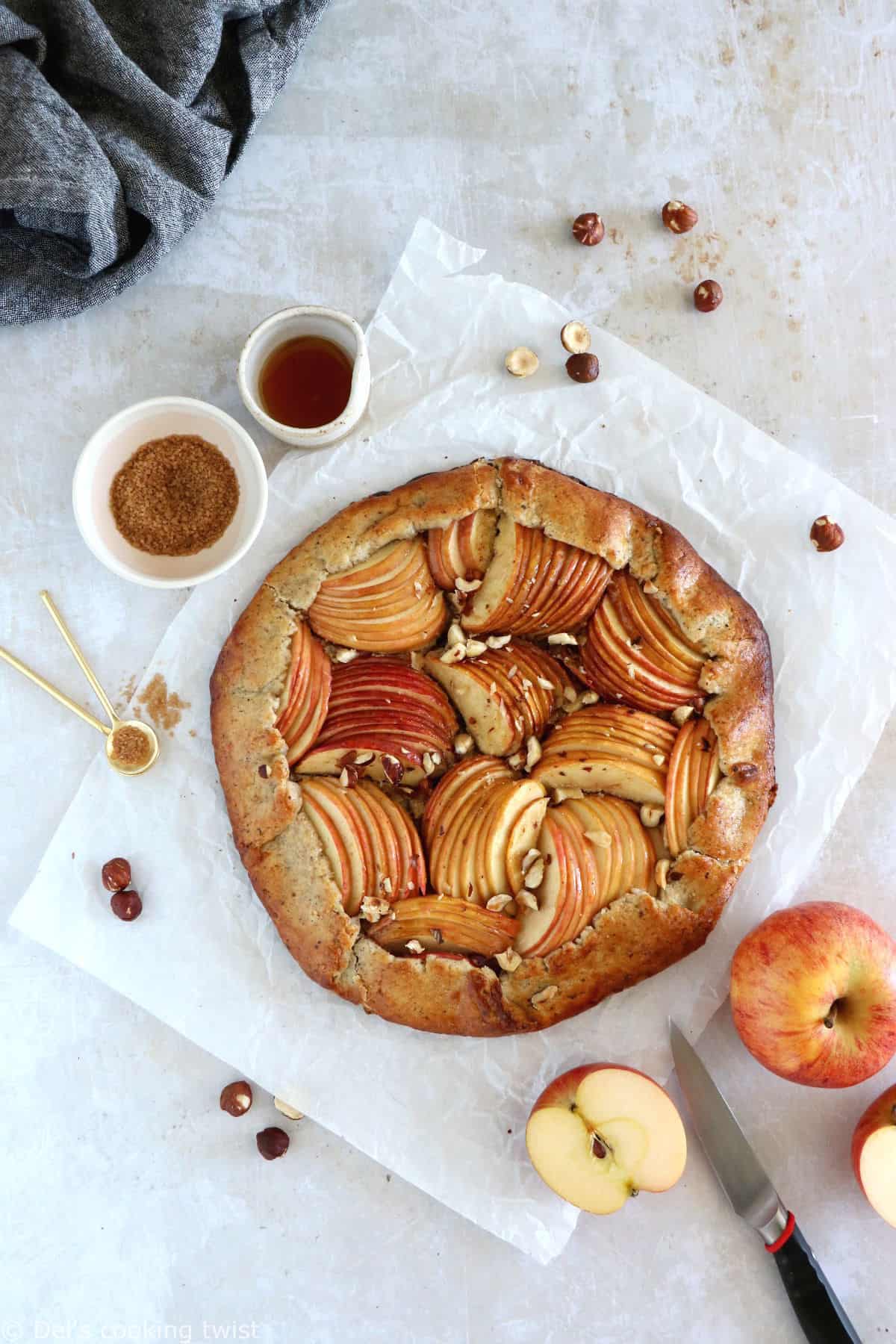 La tarte rustique aux pommes et aux noisettes est une tarte toute simple réalisée avec une pâte aux noisettes absolument irrésistible.