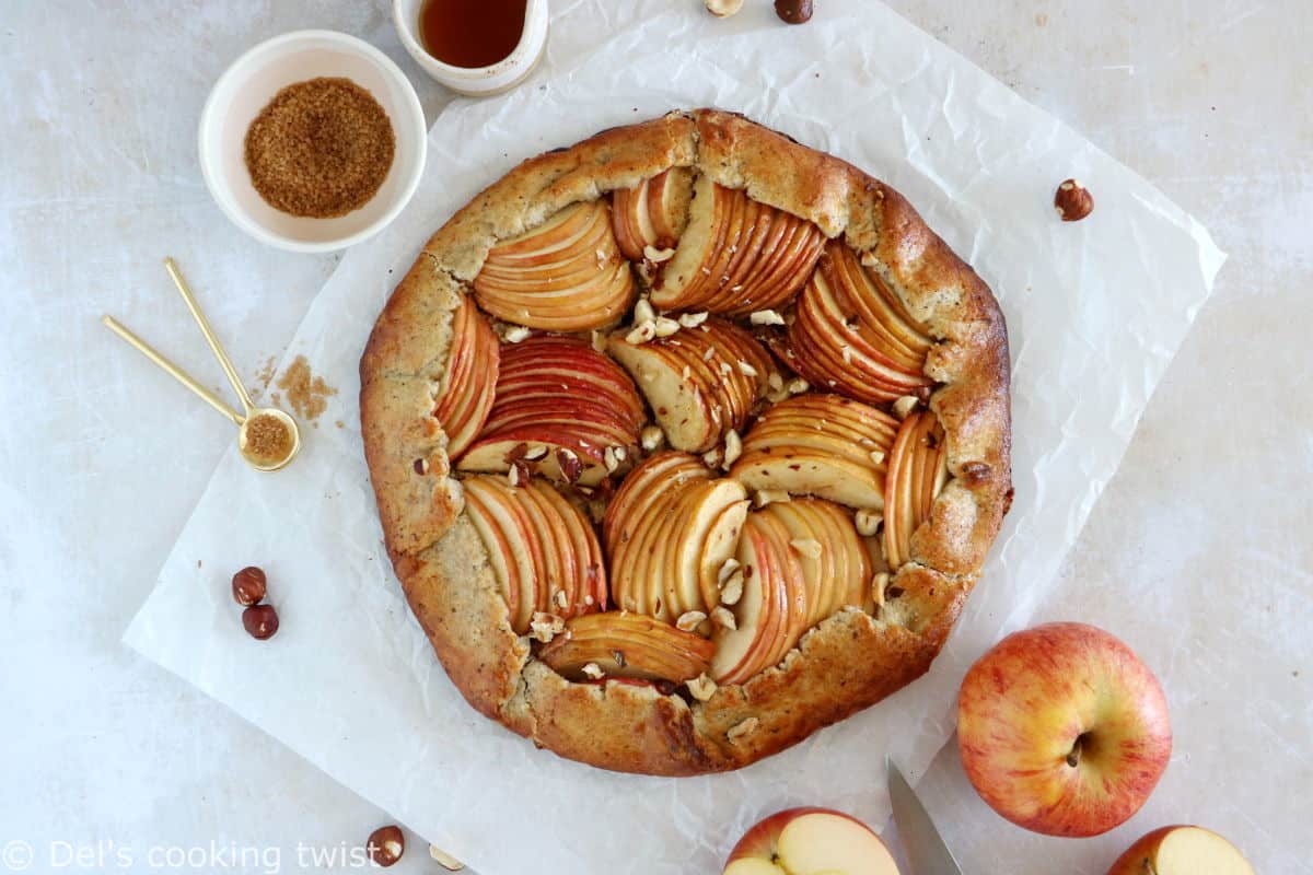 La tarte rustique aux pommes et aux noisettes est une tarte toute simple réalisée avec une pâte aux noisettes absolument irrésistible.