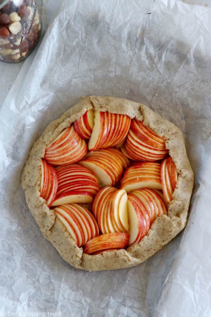 La tarte rustique aux pommes et aux noisettes est une tarte toute simple réalisée avec une pâte aux noisettes absolument irrésistible.