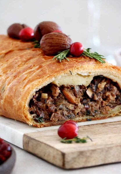 Vegetarian mushroom wellington is prepared with a simple thyme mushroom-chestnut filling wrapped inside a flaky puff pastry.