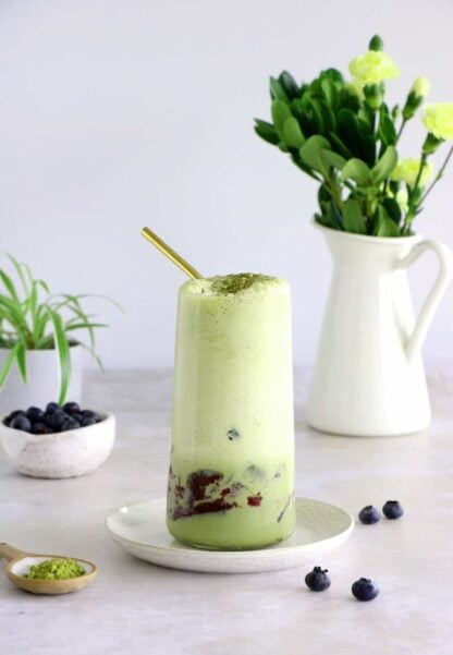 Matcha frappuccino is easy to make in a blender in just a few seconds. This frozen green tea latte is sweet and delicious, and even comes with a blueberry swirl bottom.