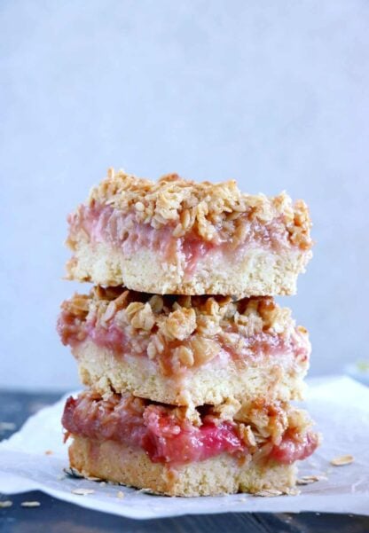 Rhubarb Crumble Bars are a must bake summer dessert recipe. They feature a thick and generous base, a juicy, sweet and tart rhubarb compote, and a crispy oat crumble on top.