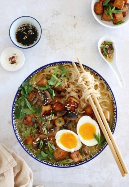 Here's a delicious tahini miso ramen with crispy tofu, sautéed mushrooms, soft boiled eggs, and a broth loaded with umami and slightly spicy flavors.